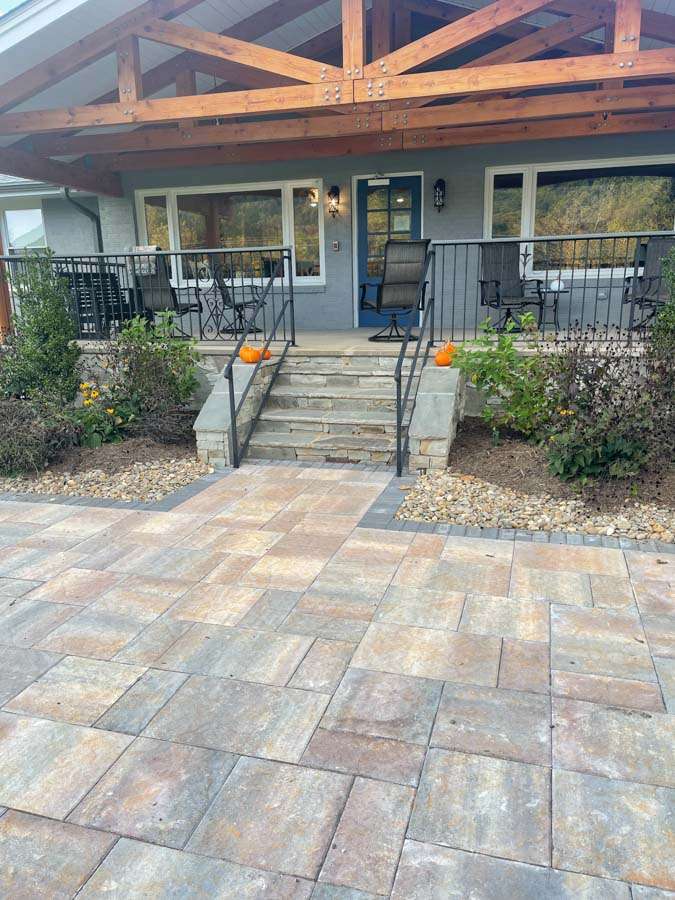 Front porch entryway with expertly crafted stone steps and a paved walkway, showcasing professional masonry services in Etowah, NC, designed for a polished and welcoming home exterior.
